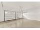 A clean and spacious three car garage with finished floors, white doors and openers, and painted white walls at 11057 Hollow Bay Dr, Winter Garden, FL 34787