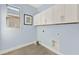 Light blue laundry room with white shaker style cabinets and wood look flooring at 11057 Hollow Bay Dr, Winter Garden, FL 34787