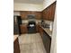 Well-equipped kitchen features wooden cabinets, tile flooring, and stainless steel appliances at 12527 Floridays Resort Dr # 506-E, Orlando, FL 32821
