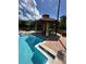 Tranquil pool area with a covered gazebo and comfortable lounge chairs for ultimate relaxation at 12527 Floridays Resort Dr # 506-E, Orlando, FL 32821