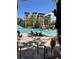 Resort swimming pool features lounge chairs, vacation rental buildings, and swaying palm trees at 12527 Floridays Resort Dr # 506-E, Orlando, FL 32821