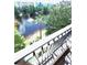 Balcony view features a lake with water fountain, lush foliage, and resort buildings at 12527 Floridays Resort Dr # 506-E, Orlando, FL 32821