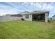View of the backyard with a screened in porch, green lawn and vinyl fence at 1323 Berry Ln, Davenport, FL 33837