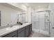 Bathroom featuring a double sink vanity with gray cabinets and a glass enclosed shower at 1323 Berry Ln, Davenport, FL 33837