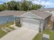 Aerial view of a home with a two-car garage, driveway, and landscaped front yard at 1323 Berry Ln, Davenport, FL 33837