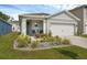 Inviting home featuring manicured landscaping, a covered entrance, and a two-car garage at 1323 Berry Ln, Davenport, FL 33837