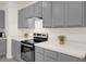 Stainless steel oven and cooktop with gray cabinets and light countertops at 1323 Berry Ln, Davenport, FL 33837