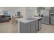 Modern kitchen features stainless steel appliances, gray cabinets, and an island with a sink at 1323 Berry Ln, Davenport, FL 33837