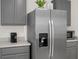 Close up view of a stainless steel refrigerator and gray cabinets at 1323 Berry Ln, Davenport, FL 33837