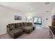 Carpeted living room with a large sectional couch and sliding glass doors to the backyard at 1323 Berry Ln, Davenport, FL 33837