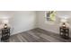 Bedroom showcasing sleek gray wood flooring, a window, and decorative side tables with lamps at 1341 W Belmar St, Lakeland, FL 33815