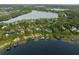 Aerial view of a waterfront property featuring a private dock, pool, and beautifully landscaped grounds at 1455 Kelso Blvd, Windermere, FL 34786