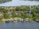 An aerial view of a home with a private dock and boat lift surrounded by lush greenery and serene lake waters at 1455 Kelso Blvd, Windermere, FL 34786