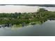 An aerial view of a lakeside home surrounded by lush greenery and serene waters at 1455 Kelso Blvd, Windermere, FL 34786