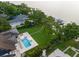 Aerial view of a property with a pool, manicured lawn, and lake access with a private dock at 1455 Kelso Blvd, Windermere, FL 34786