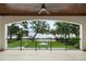 Covered porch with view of expansive lawn, landscaping and a dock on the water at 1455 Kelso Blvd, Windermere, FL 34786