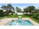Backyard featuring a pool, manicured lawn, mature trees, and a dock on the water at 1455 Kelso Blvd, Windermere, FL 34786