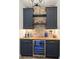 Stylish bar area with custom cabinets, open shelving, a wine cooler, and elegant decor at 1455 Kelso Blvd, Windermere, FL 34786