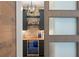 Close up of the bar area with stone backsplash, wine fridge and a decorative light fixture at 1455 Kelso Blvd, Windermere, FL 34786