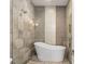 This bathroom features a soaking tub, elegant stone tiling and glass enclosed shower at 1455 Kelso Blvd, Windermere, FL 34786