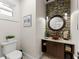 Powder room features decorative lighting, eye-catching mirror, modern sink and unique tile accent wall at 1455 Kelso Blvd, Windermere, FL 34786