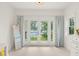 Bedroom with white walls, carpet, and french doors opening onto a balcony overlooking a lake at 1455 Kelso Blvd, Windermere, FL 34786