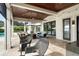 Expansive covered patio featuring a tile floor, ceiling fans, and comfortable seating with an outdoor fireplace at 1455 Kelso Blvd, Windermere, FL 34786