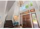 Grand foyer with high ceilings, dark wood floors, elegant chandelier, and wooden double doors with sidelights at 1455 Kelso Blvd, Windermere, FL 34786