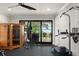 Well-equipped home gym featuring a sauna, lake view, and rubber flooring for comfortable workouts at 1455 Kelso Blvd, Windermere, FL 34786