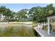 Expansive lake view showcasing the property with mature trees, a white retaining wall and a private boat dock at 1455 Kelso Blvd, Windermere, FL 34786