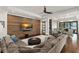 Bright living room featuring a sectional sofa, wood accent wall with TV, and view to the outside patio at 1455 Kelso Blvd, Windermere, FL 34786