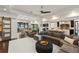 Open-concept living room showcasing a large sectional sofa, wood floors, and views to the patio and kitchen at 1455 Kelso Blvd, Windermere, FL 34786
