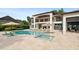 Back of house featuring a pool with tanning chairs, landscaped backyard, and water view at 1455 Kelso Blvd, Windermere, FL 34786