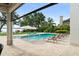 Inviting pool with lounge chairs and a tranquil lake view from the covered patio at 1455 Kelso Blvd, Windermere, FL 34786