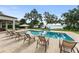 Stunning backyard pool area with lounge chairs and expansive lake views surrounded by mature landscaping at 1455 Kelso Blvd, Windermere, FL 34786