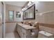 Bathroom featuring double sinks, large mirror, spacious countertop and traditional cabinetry with detailed hardware at 146 Tollgate Trl, Longwood, FL 32750