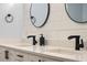 Close-up on modern bathroom featuring dual sinks, sleek black fixtures, and stylish mirrors at 146 Tollgate Trl, Longwood, FL 32750