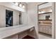 Bright vanity with mirror and open door to bathroom with cabinets, sink, and marble countertop at 146 Tollgate Trl, Longwood, FL 32750