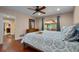 Comfortable bedroom with cherry floors, ceiling fan, and queen-sized bed with patterned linens at 146 Tollgate Trl, Longwood, FL 32750