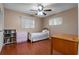 Cozy bedroom with cherry floors, ceiling fan, two windows, twin bed, pink dresser, and brown desk at 146 Tollgate Trl, Longwood, FL 32750
