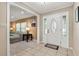 Bright foyer featuring tiled floors, a decorative front door, and a glimpse into the cozy living area at 146 Tollgate Trl, Longwood, FL 32750