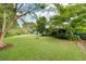 Spacious backyard with a well-maintained lawn, mature trees, and glimpses of the house at 1516 Arthur St, Orlando, FL 32804