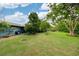 Lush green backyard with mature trees, lawn, and a glimpse of the home's exterior at 1516 Arthur St, Orlando, FL 32804