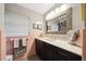 Bathroom featuring pink tiled walls, gray floors, dark cabinets, and a decorative mirror at 1516 Arthur St, Orlando, FL 32804