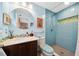 Stylish bathroom with vanity, large round mirror, and blue tiled shower at 1516 Arthur St, Orlando, FL 32804