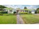 Charming blue home with well-manicured front yard, lush landscaping, and inviting brick walkway at 1516 Arthur St, Orlando, FL 32804