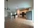 Open kitchen boasts tile floors, stainless steel appliances, and light cabinets with black countertops at 15637 Carina Dr, Orlando, FL 32828