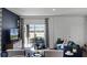 Cozy living room featuring a blue sofa, stylish curtains, and sliding glass doors to the outdoor space at 16341 Lakelet Aly, Winter Garden, FL 34787