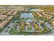 Aerial view of a resort-style community pool, clubhouse, and tennis courts by a lake at 2186 Tripoli Ct, Kissimmee, FL 34747