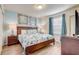 Well-lit bedroom with wood-look floors, blue walls, matching nightstands and curtains at 2186 Tripoli Ct, Kissimmee, FL 34747